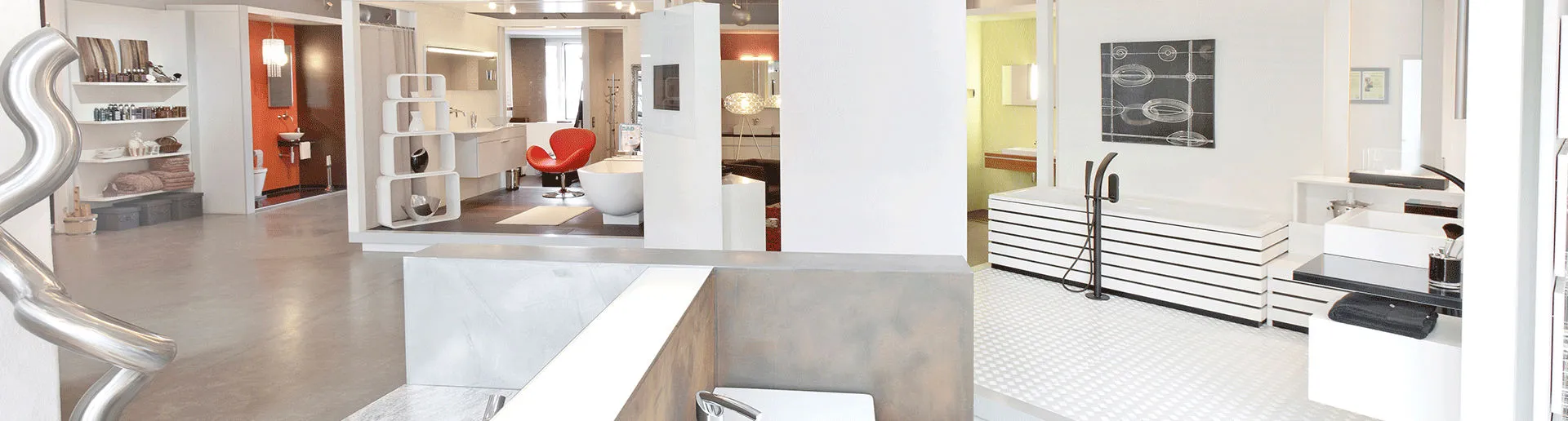 Ein heller Showroom zeigt verschiedene Designer-Badewannen, Waschbecken und Armaturen in hellen, stilvollen Räumen mit minimalistischen Akzenten.