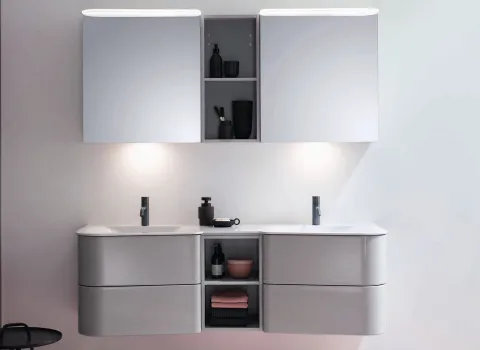 Moderner Burgbad-Spiegelschrank mit integrierter Beleuchtung, zwei Waschbecken und Stauraum, darunter graue Schubladen und offene Regale.