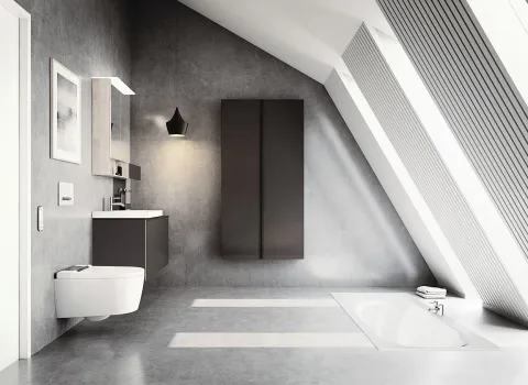 Das lichtduchflutete Badezimmer unter einer Dachschräge ist mit einem Geberit AquaClean Sela-Dusch-WC ausgestattet, das links neben einem schicken Waschtisch platziert ist.