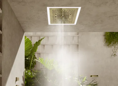 Ein luxuriöser, moderner hellbeiger Duschbereich mit Regendusche Serenity Sky von Dornbracht und grünen Pflanzen.