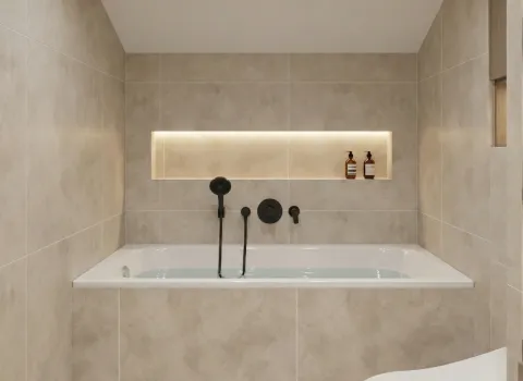 Geflieste Badewanne in neutralem Beige mit wandintegriertem Regal und mattschwarzer Handbrause.