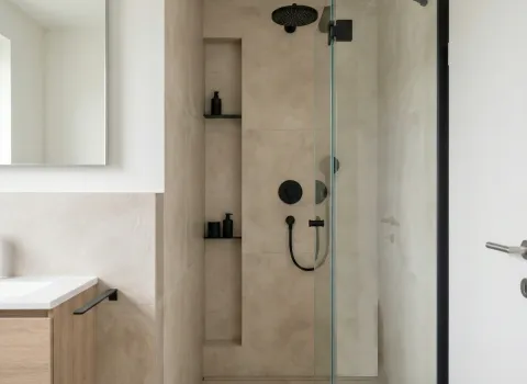 Zeitloses Duschdesign mit Glaswand, integrierter Duschablage und minimalistischer Ausstattung in Beige und Schwarz.