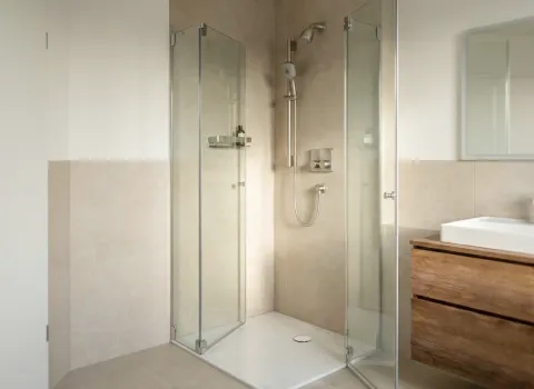 Minimalistisch gestaltete Duschkabine mit Glasabtrennung und bodenebener Duschtasse im stilvollen Bad.