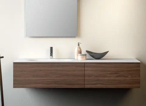 Schwebendes Stocco Badmöbel mit warmer Holzfront, weißer Waschtischplatte und minimalistischer Wandgestaltung.