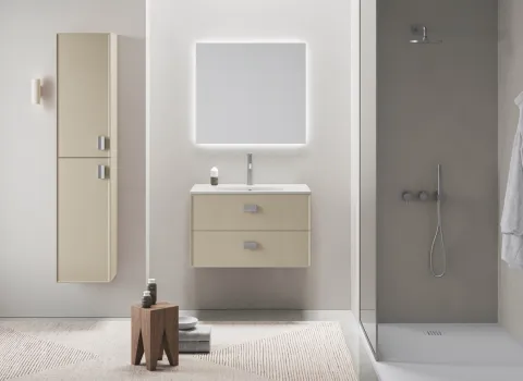 Wandhängendes Badmöbel in Beige mit Chromgriffen, beleuchtetem Spiegel und bodengleicher Dusche.