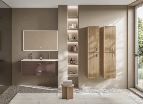 Badmöbel-Kombination mit braunem Waschtisch und Hochschränken in heller Holzoptik in warmem Licht.