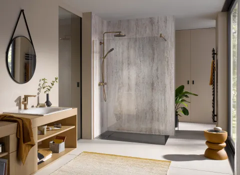 Walk-in-Dusche des Herstellers HSK mit goldener Duscharmatur.