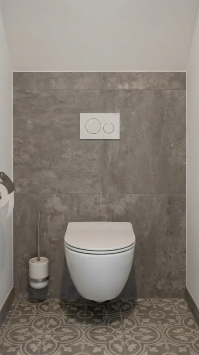Stilvoll eingerichtetes Gäste-WC mit platzsparender Hängetoilette, dunklen Wandfliesen und Designboden.