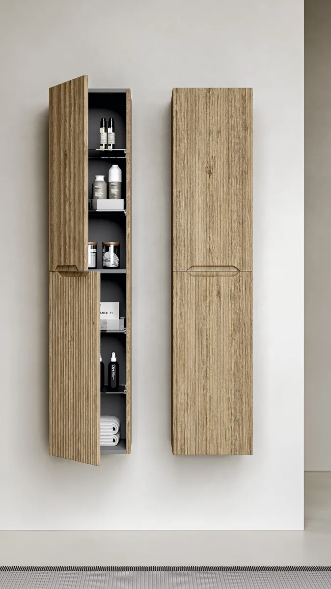 Stocco Hochschrank mit geriffelter Eichenfront und geöffnetem Stauraumfach im modernen Bad.