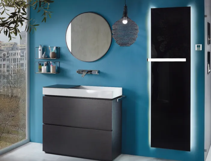 Schwarzer Badheizkörper Plawa von Bemm vor einer blauen Wand neben einem Waschplatz im Badezimmer.